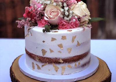 single-tier-elegant-wedding-cake-design-with-floral-arrangement-and-gold-leaf-temecula
