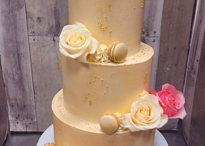yellow-three-tier-wedding-cake-with-pink-and-yellow-roses-in-the-bakery-temecula